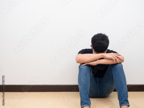 Drepressed man sit and head down on the floor white wall sad man concept