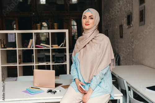 modern muslim woman in hijab in office room photo