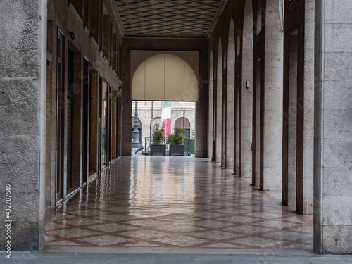 Long Empty Corridor under the Arcades of a Deserted City with Stores Closed Due to the Covid-19 Pandemic