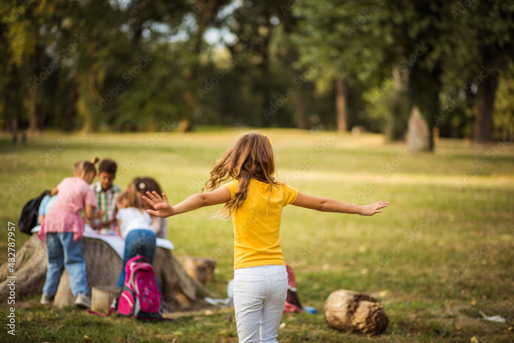Fototapeta premium Large group of school kids in nature. Dancing girl.