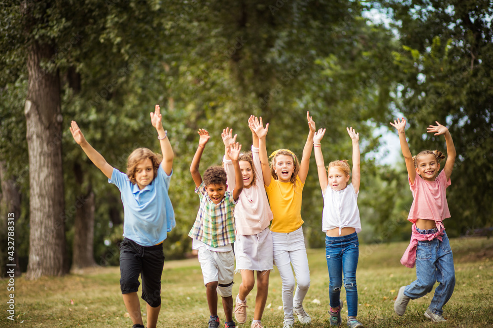 Obraz premium Large group of school kids having fun in nature. Wonderful childhood.