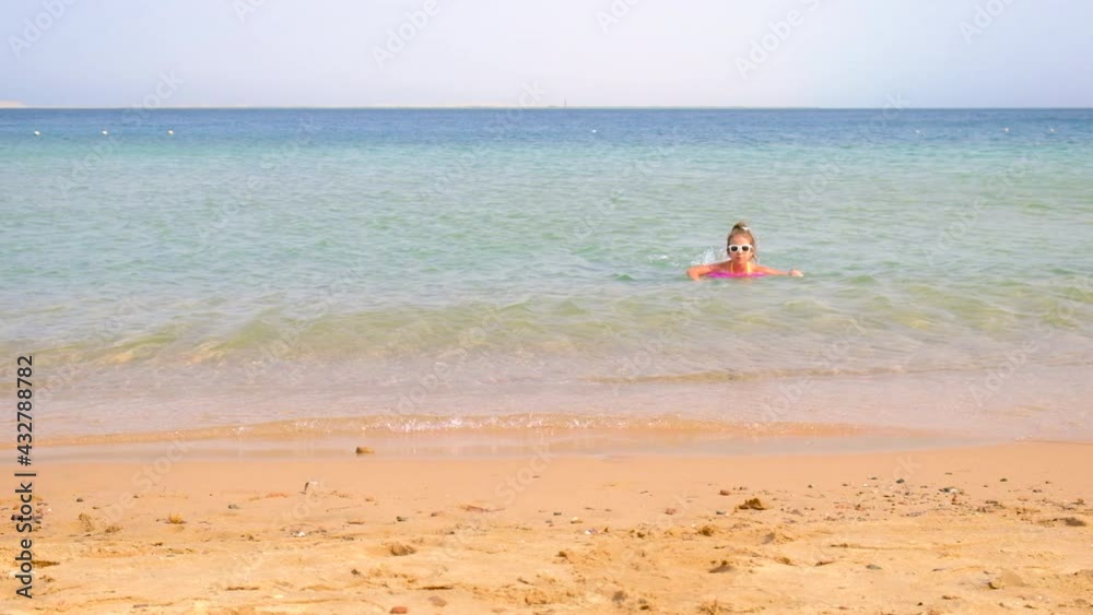 The child runs into the sea. Selective focus. The child runs into the sea. Selective focus.