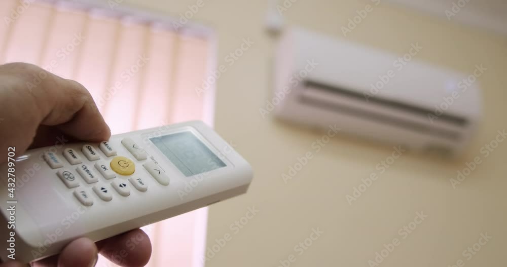 Close-up, a man turns off the air conditioner by pressing a button on the remote control. Close-up, a man turns off the air conditioner by pressing a button on the remote control.