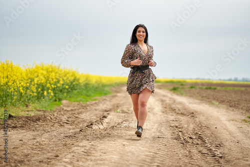 Fotografia Plus size woman by a canola field