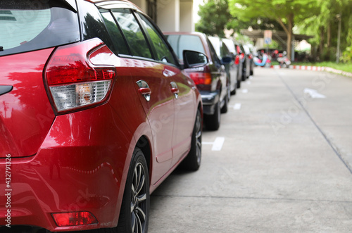 Closeup of rear, back side of red car with  other cars parking in outdoor parking area. © Amphon