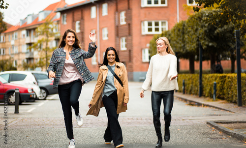 Three women having fun on the street.  Always is funny time with friends. © liderina