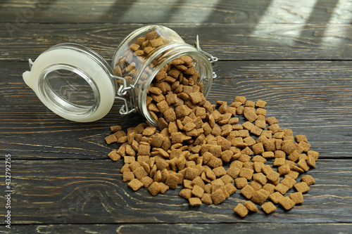 Glass jar with pet feed on wooden background