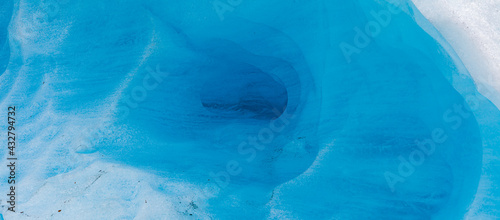 Close up in panorama format of the melting blue ice of a tongue of the Svartisen glacier, Holandsfjord, Nordland, Norway