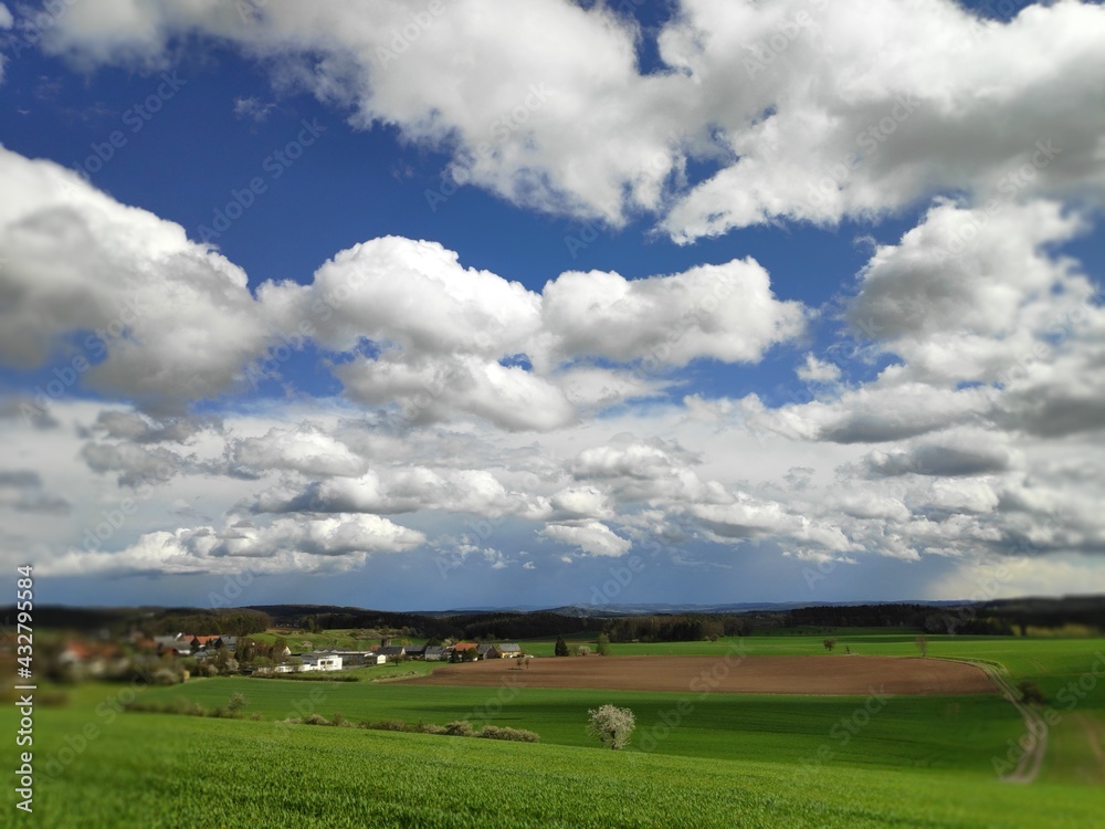 A skyscape of clouds over fields and settlement in Bavaria, Germany A skyscape of clouds over fields and settlement in Bavaria, Germany