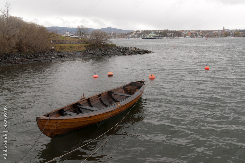 Naklejka premium wooden boat off the coast