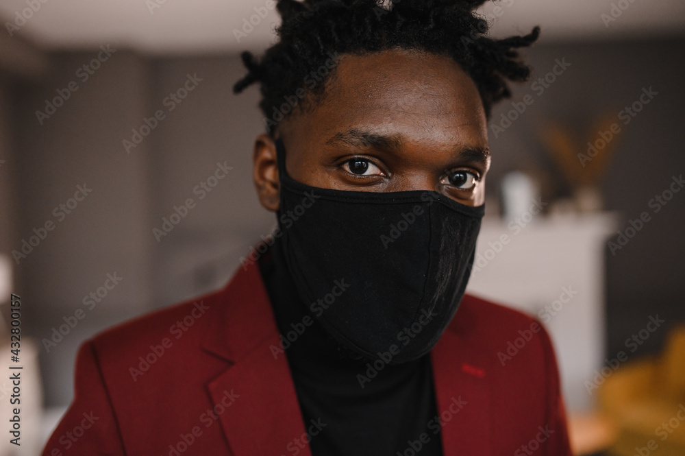 portrait of an afro american in a suit wears a black medical mask portrait of an afro american in a suit wears a black medical mask
