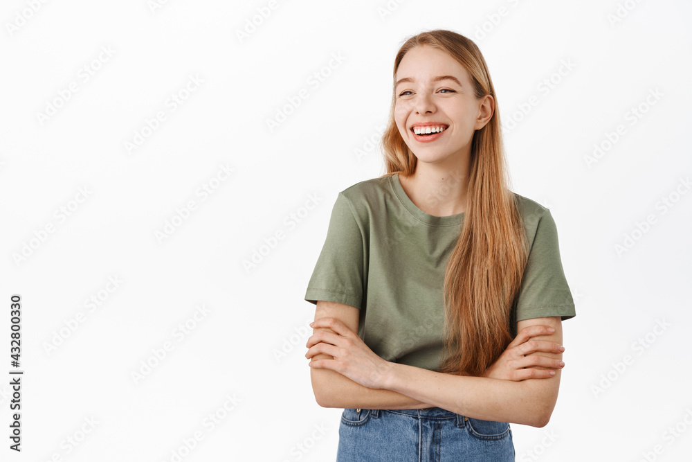 Happy candid girl laughing and smiling, looking aside at advertisement logo with pleased face, standing as if having casual relaxing conversation with friends, white background