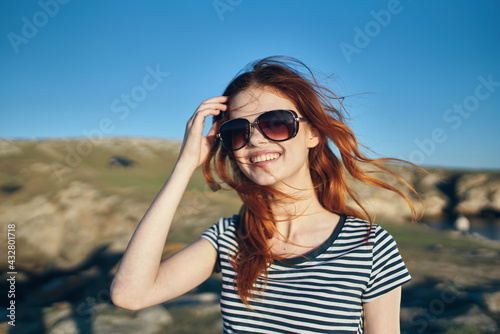 happy woman in striped t-shirt and sunglasses mountains and blue sky summer vacation