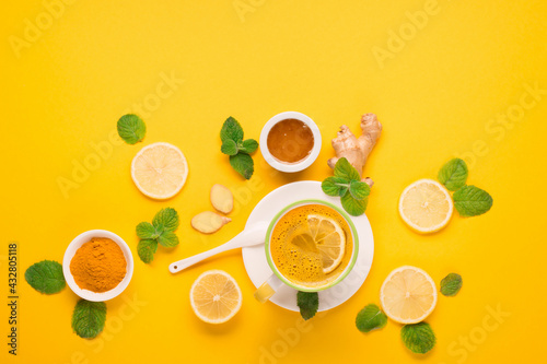 Turmeric milk drink with fresh  mint  ginger  lemon  honey on paper yellow background.