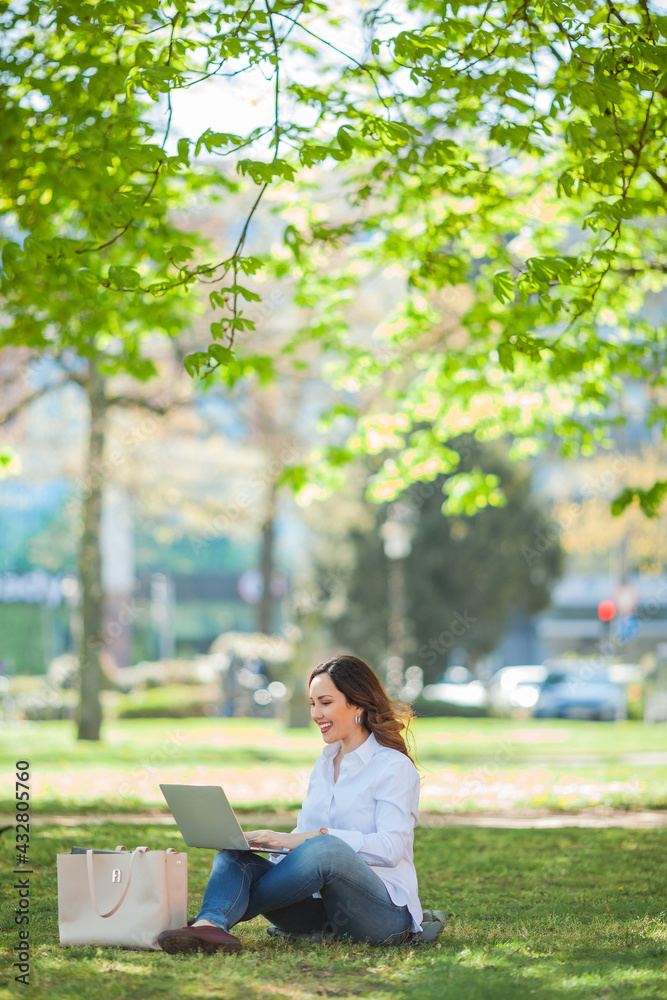 Young happy woman works at a laptop in nature. Quarantine. Freelancer. Young happy woman works at a laptop in nature. Quarantine. Freelancer.