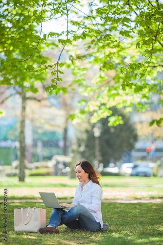 Free Download Young happy woman works at a laptop in nature. Quarantine. Freelancer. - GFXLoad