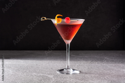 Traditional Manhattan cocktail with cherry on gray stone