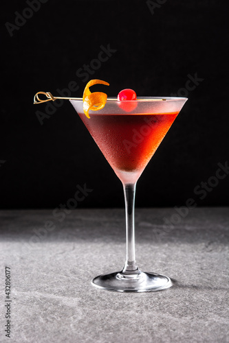 Foto Traditional Manhattan cocktail with cherry on gray stone