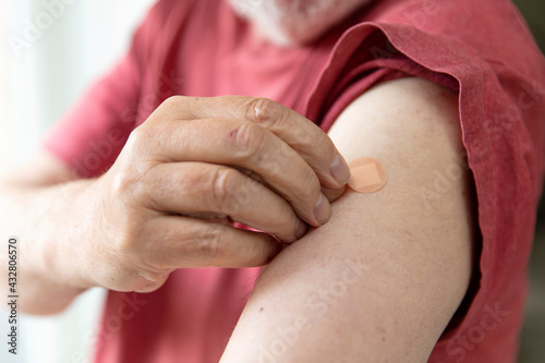 Caucasian man with a plaster on their arm after a vaccination injection