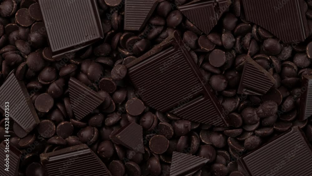 Chocolate. broken dark chocolate bar and chocolate chips top view, rotation