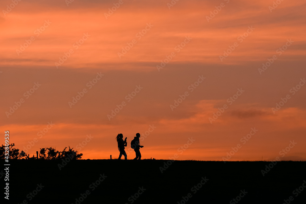 people walking in the country with a beautiful sunset