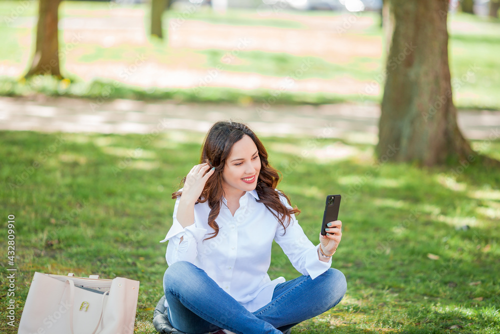 Young happy woman speaks by video call in nature. Quarantine. Young happy woman speaks by video call in nature. Quarantine.