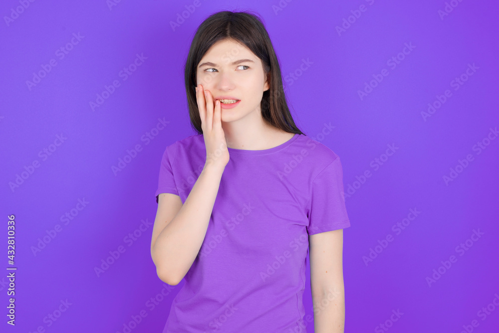Tooth ache concept. Indoor shot of young female feeling pain, holding his cheek with hand, suffering from bad toothache, looking at camera with painful expression Tooth ache concept. Indoor shot of young female feeling pain, holding his cheek with hand, suffering from bad toothache, looking at camera with painful expression