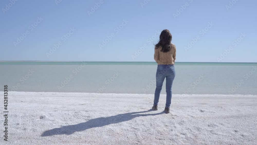 Woman arrives to pristine turquoise beach made from white shells. Time for freedom and vacations Woman arrives to pristine turquoise beach made from white shells. Time for freedom and vacations