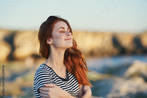 woman travels in the mountains in nature near the river and striped t-shirt