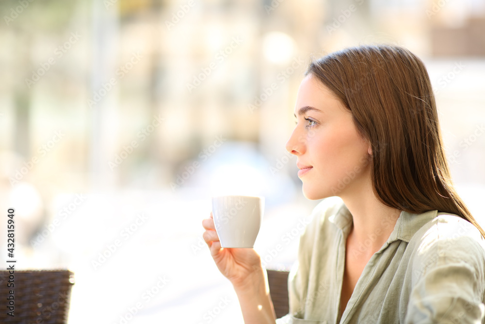 Woman drinking coffee looking away in a bar - obrazy, fototapety, plakaty 