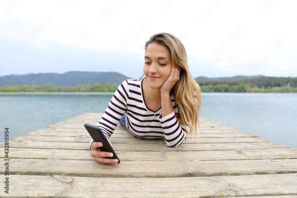 Woman checking smart phone in a lake