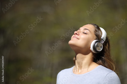 Woman meditating wearing headphones in a park