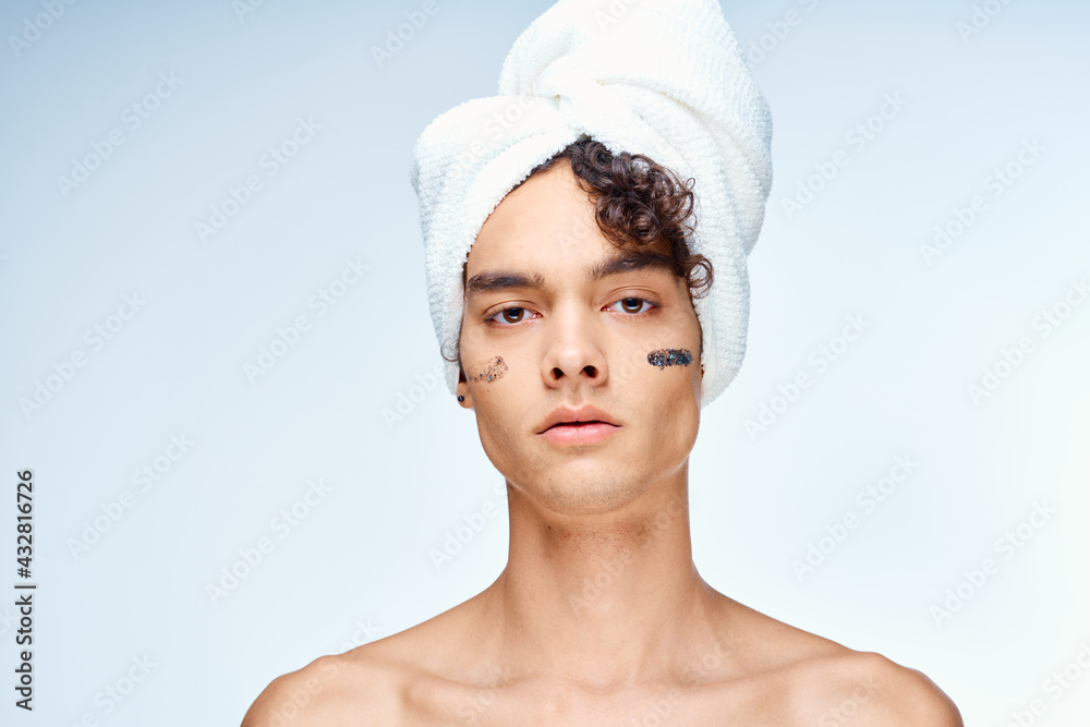 man with bare shoulders towel on head cream clean skin cosmetology