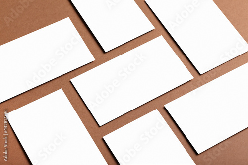 Empty White invitation card or business card mockup on a brown table.