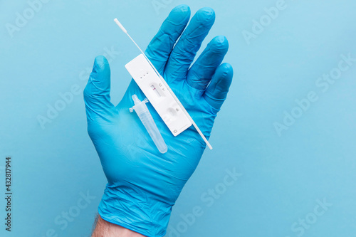 Doctor in blue gloves using a lateral flow covid-19 testing kit photo