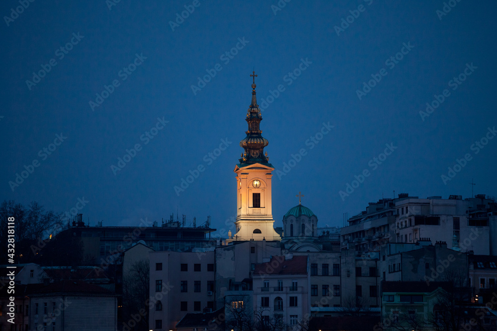 Panorama of old city of Belgrade at night with a selective blur on Saint Michael Cathedral, also known as Saborna Crkva, with iconic clocktower seen from afar. Belgrade is capital city of Serbia...