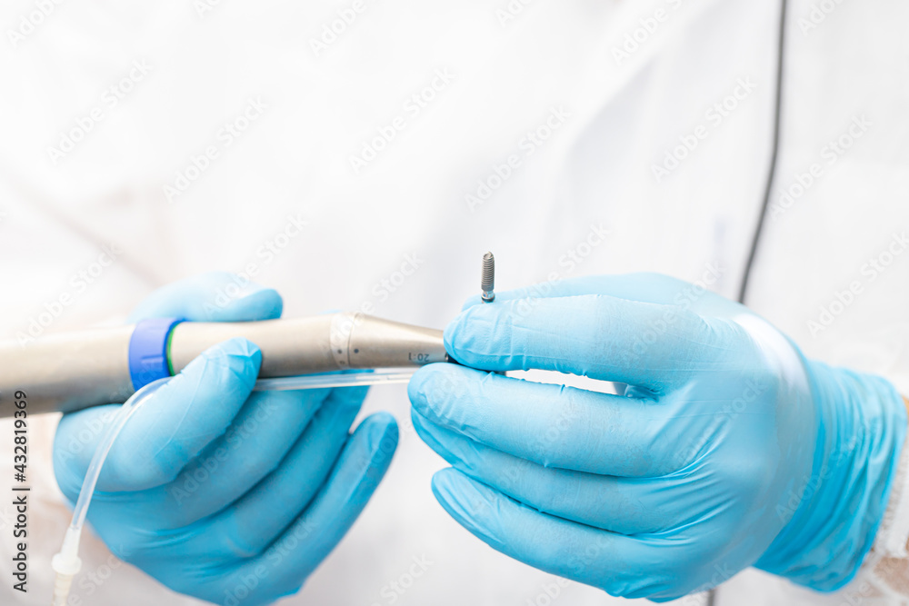 the dentist holds the instrument during the dental implant surgery the dentist holds the instrument during the dental implant surgery