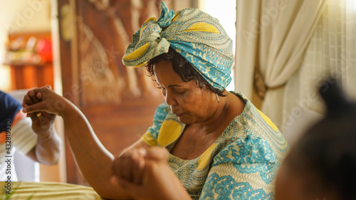 Elderly woman praying at breakfast table