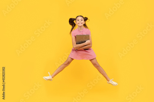 Fototapeta Naklejka Na Ścianę i Meble -  happy kid girl jumping with laptop go online shopping, discount