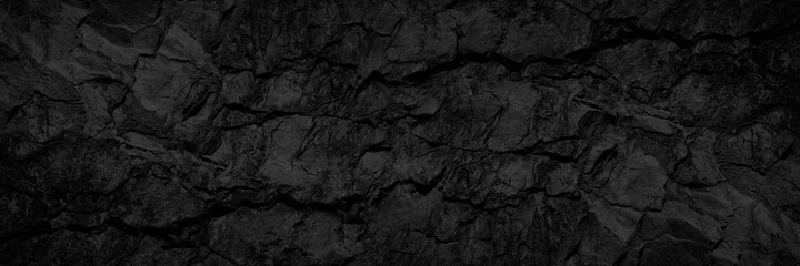 Rock texture with cracks. Black stone background with copy space for design. Wide banner.