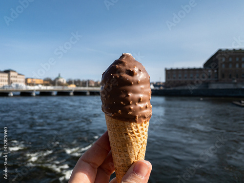 Ice cream in cone with orange brittle and chocolate in the city of Stockholm