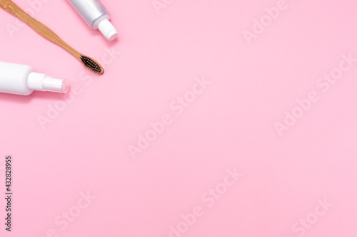 Eco and hygiene. A bamboo toothbrush, mouth freshener and toothpaste. Flat lay. Pink background. Copy space. The concept of eco-friendly hygiene tools