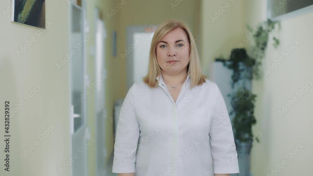 Portrait of a female doctor in a white coat looking at the camera. Portrait of a female doctor in a white coat looking at the camera.