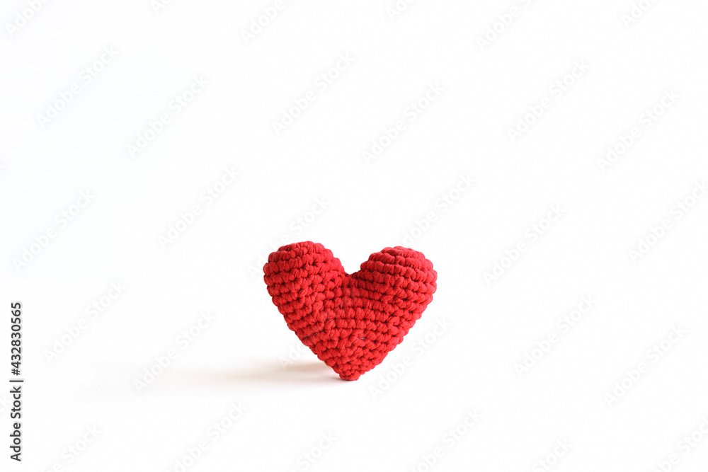 Handmade red crochet heart on white background