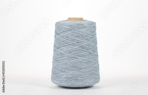 Gray spool of yarn on a white background. Side view. Textile spool on an isolated white background.