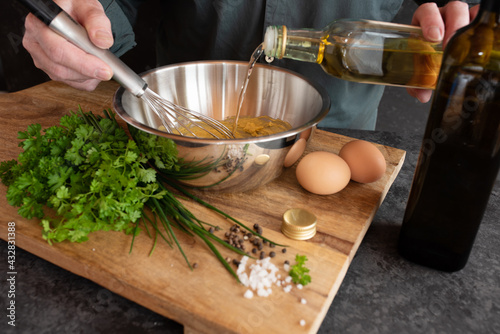 Preparing a gribiche sauce for green asparagus. Hands prepare fresh ingredients for a tasty side dish. Gastronomy and lifestyle background. Close up. photo