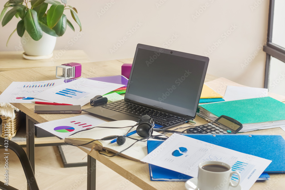 Workplace in the office. Laptop, graphs, charts, documents, papers, folders.