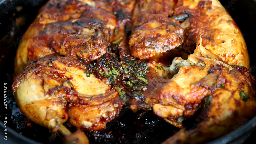 Appetizing grilled chicken in a cast-iron skillet. Delicious chicken with a golden-brown crust.