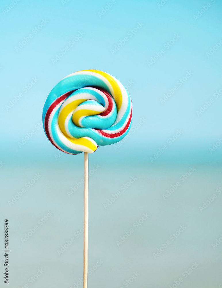 Sweet rainbow color candy on sea background.