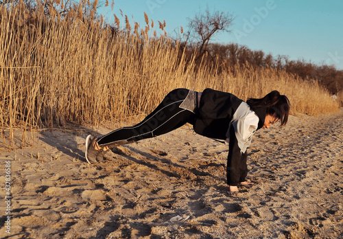 Fitness concept. Woman makes exercises outdoors.